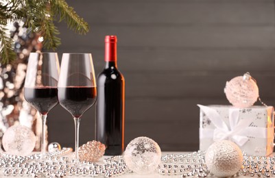 Photo of Red wine and beautiful Christmas decor on white table