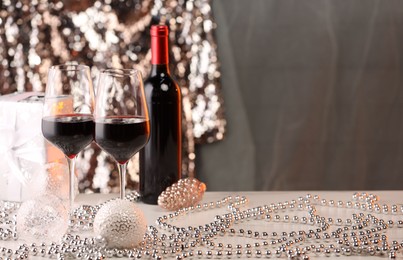 Photo of Red wine and beautiful Christmas decor on white table. Space for text