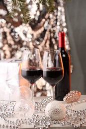 Photo of Red wine and beautiful Christmas decor on white table