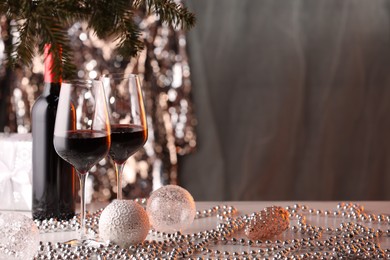 Photo of Red wine and beautiful Christmas decor on white table. Space for text