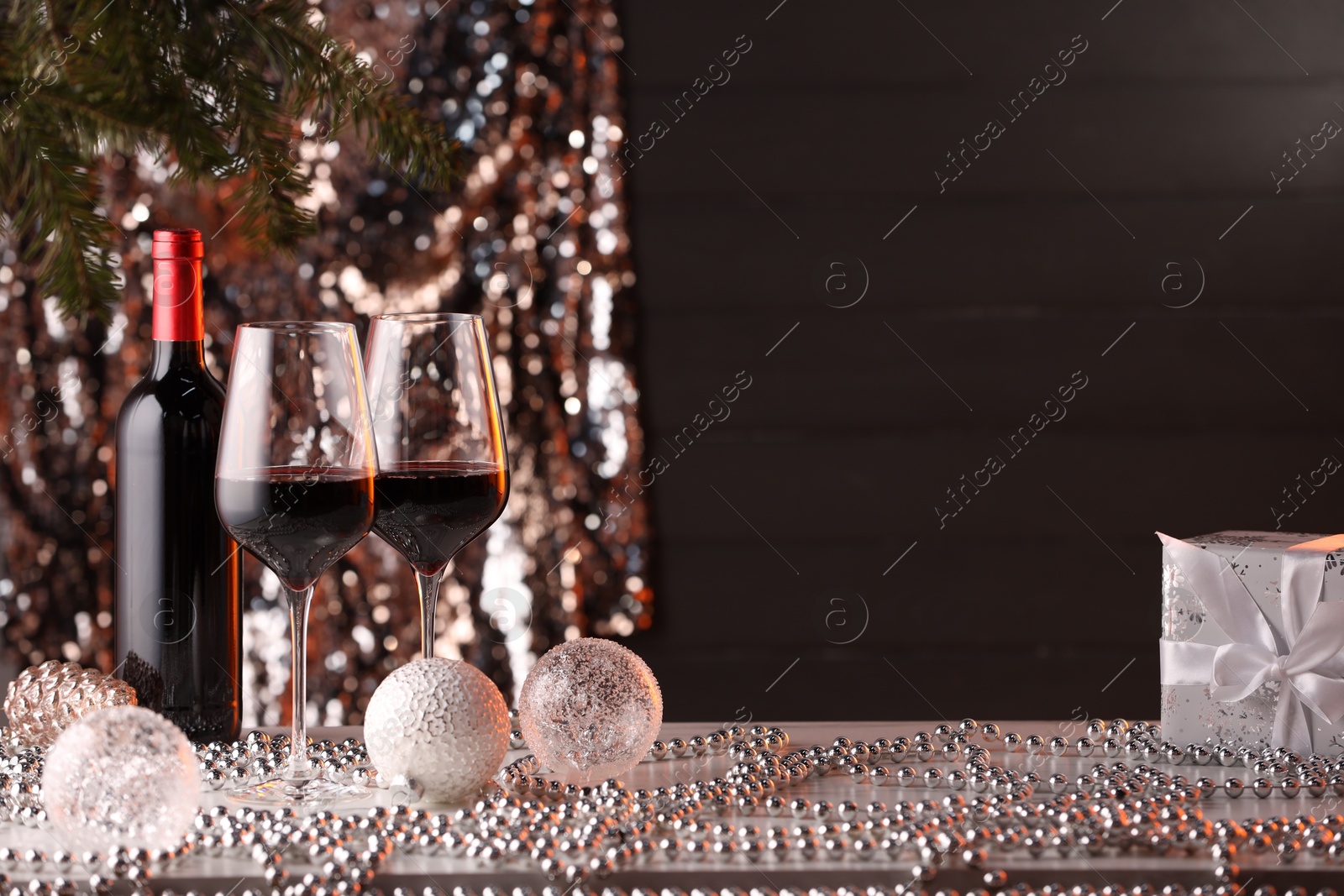 Photo of Red wine and beautiful Christmas decor on white table. Space for text