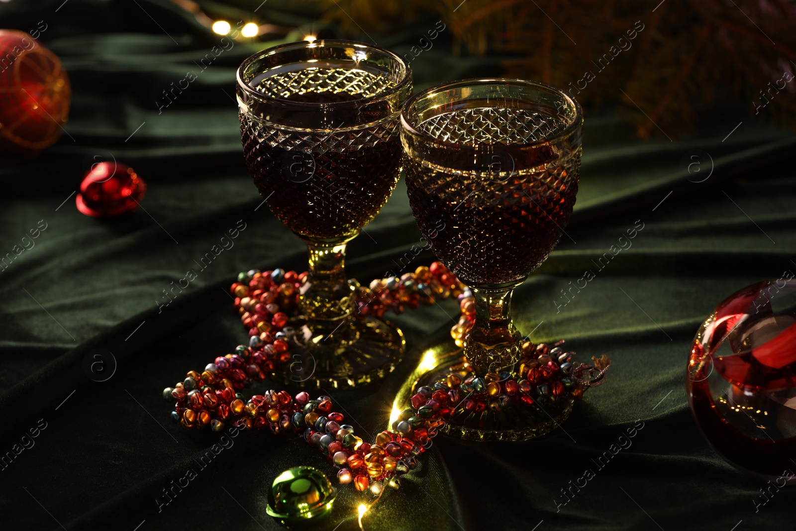 Photo of Glasses with red wine and beautiful Christmas decor on table