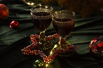 Photo of Glasses with red wine and beautiful Christmas decor on table