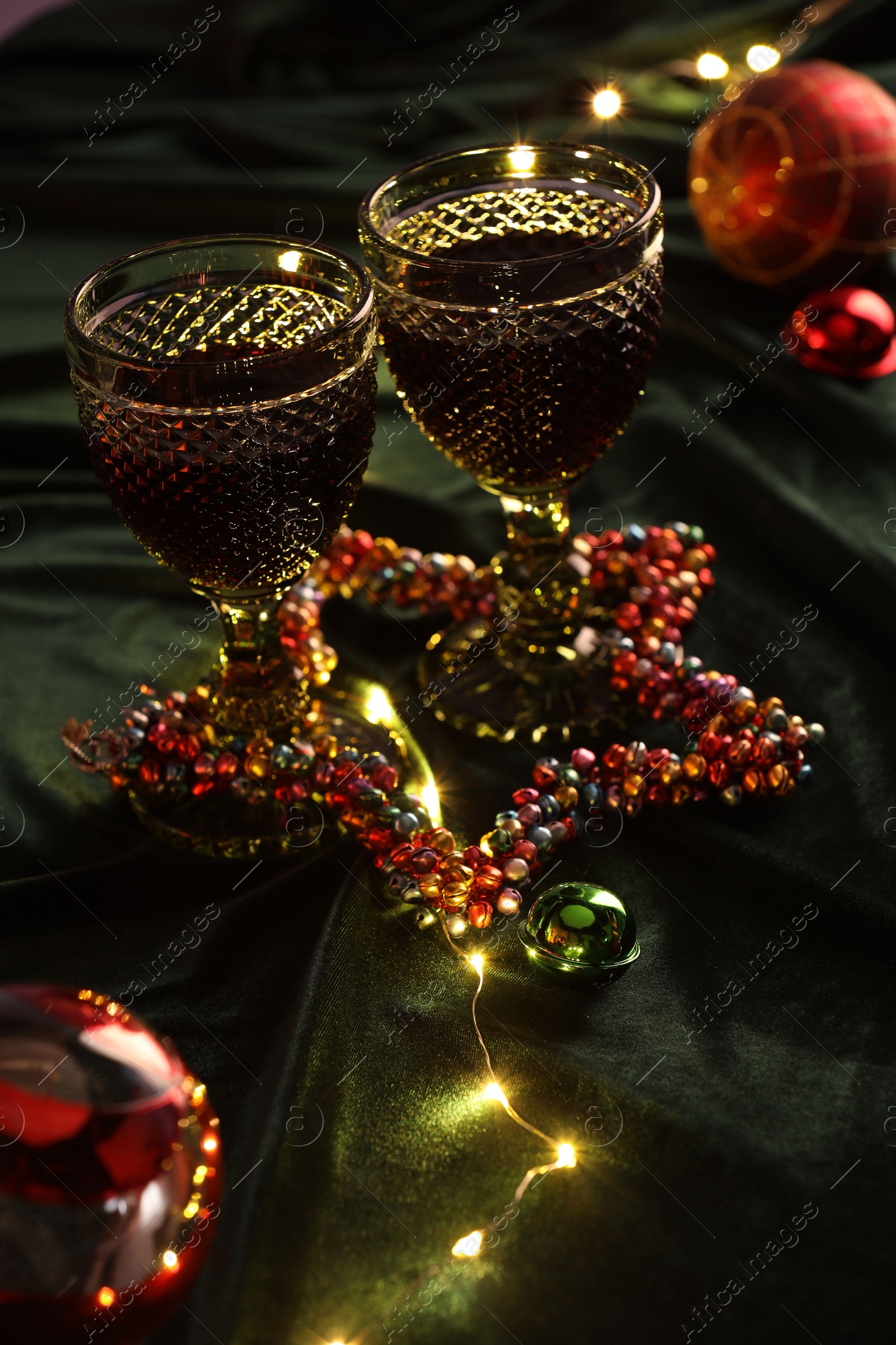 Photo of Glasses with red wine and beautiful Christmas decor on table