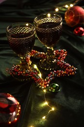 Photo of Glasses with red wine and beautiful Christmas decor on table