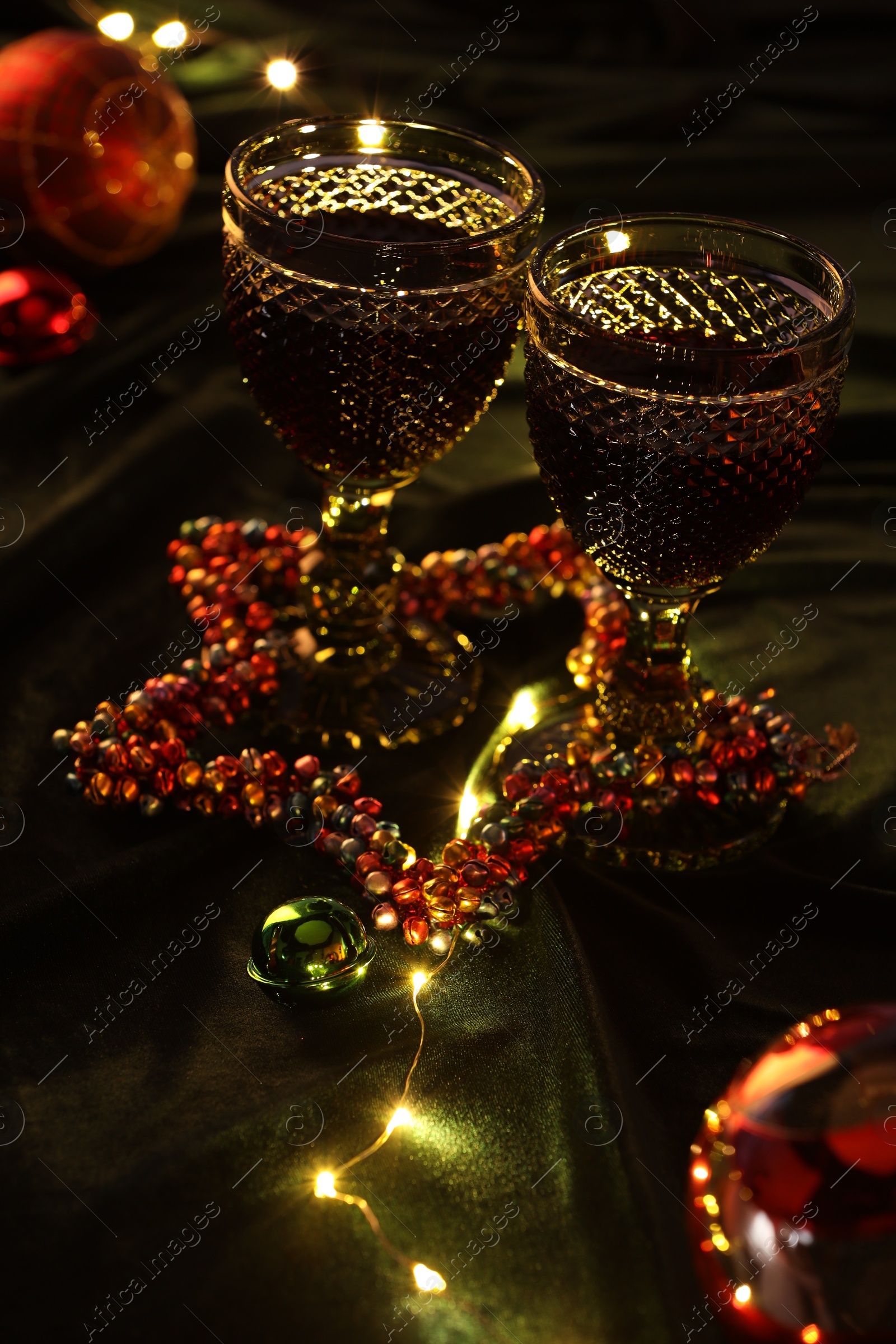 Photo of Glasses with red wine and beautiful Christmas decor on table