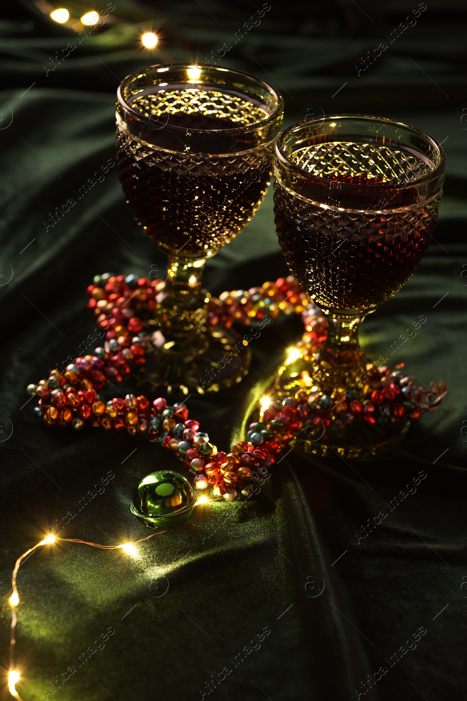 Photo of Glasses with red wine and beautiful Christmas decor on table