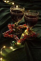 Photo of Glasses with red wine and beautiful Christmas decor on table