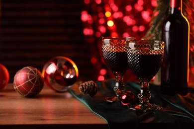 Red wine and beautiful Christmas decor on wooden table, closeup. Space for text