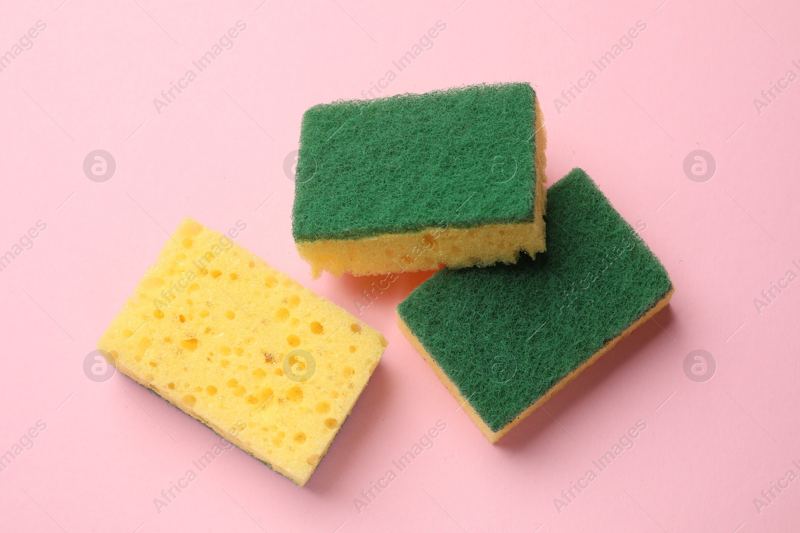 Photo of Soft sponges on pink background, top view. Cleaning tool