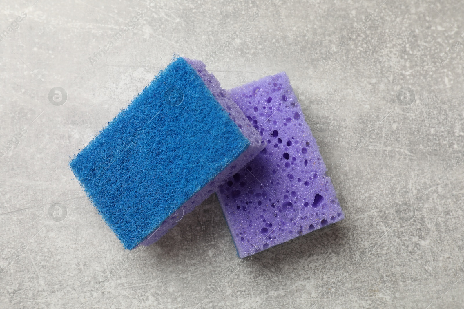 Photo of Soft sponges with foam on gray textured table, top view