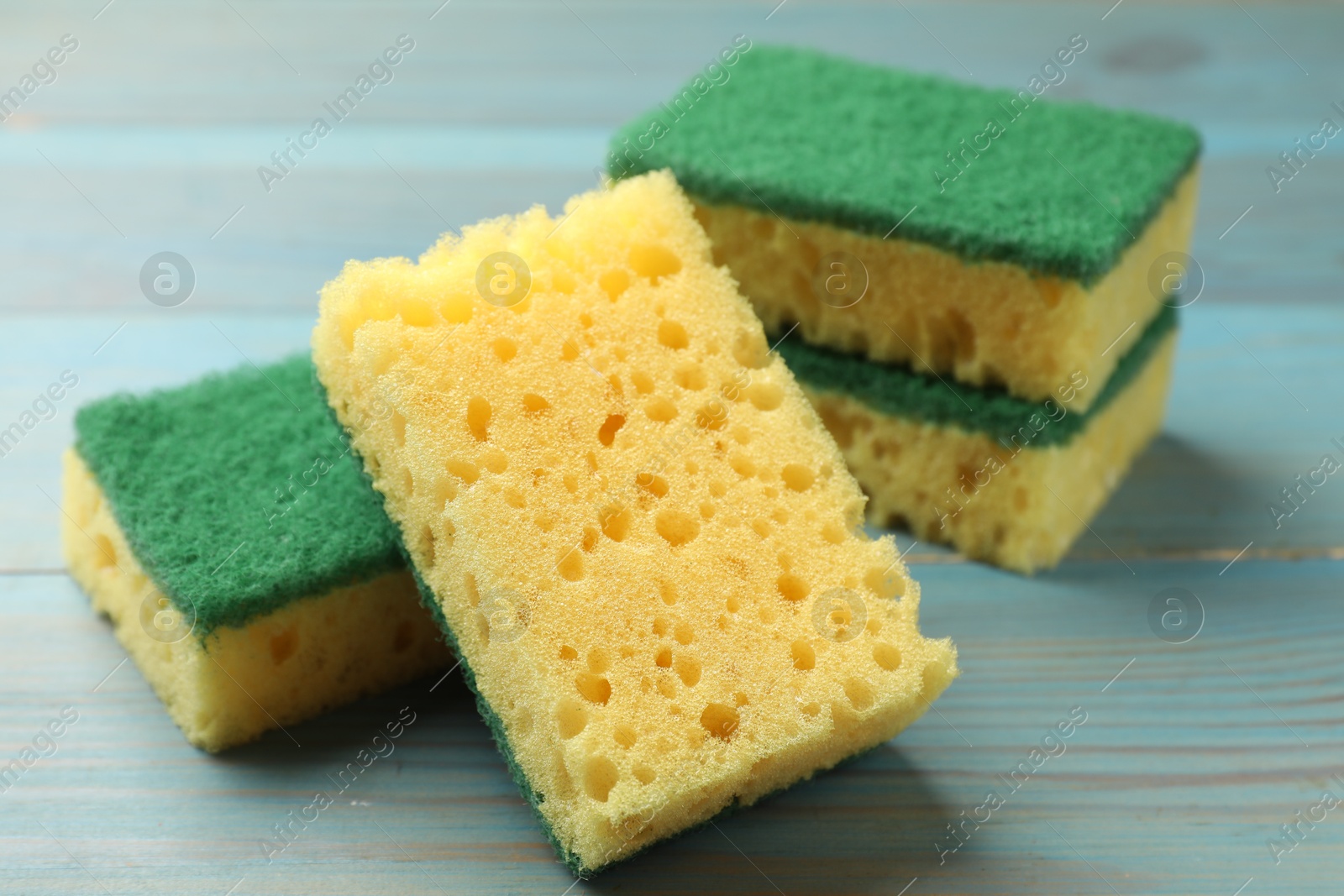 Photo of Soft sponges on light blue wooden table, closeup