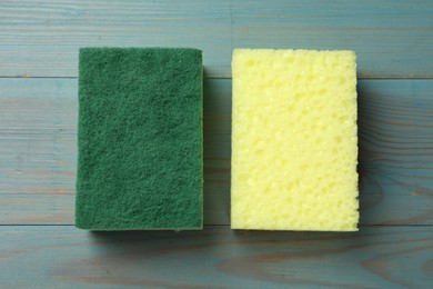 Photo of Soft sponges on light blue wooden table, top view