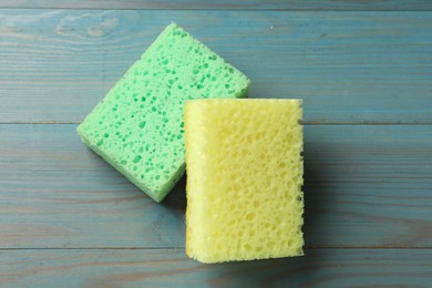 Photo of Soft sponges on light blue wooden table, top view