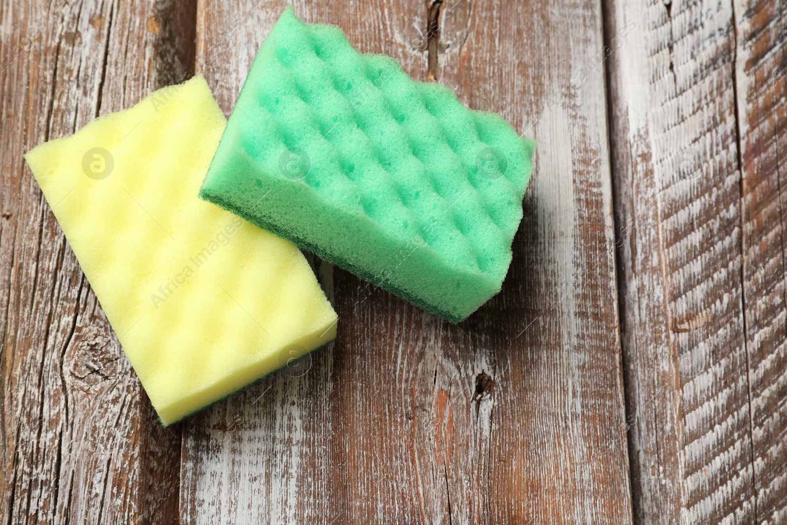 Photo of Soft sponges on wooden table, top view. Space for text