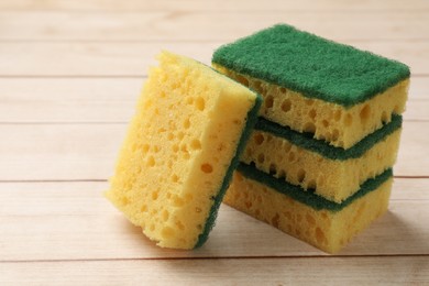 Photo of Many soft sponges on wooden table, closeup