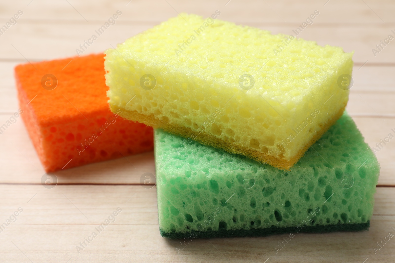 Photo of Many soft sponges on wooden table, closeup