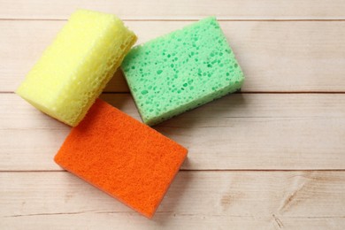 Photo of Soft sponges on wooden table, top view. Space for text