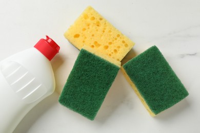 Photo of Soft sponges and dish soap on white table, flat lay