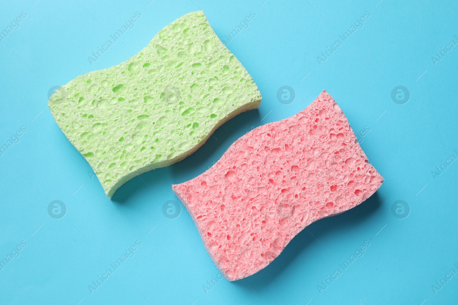 Photo of Soft sponge on light blue background, top view