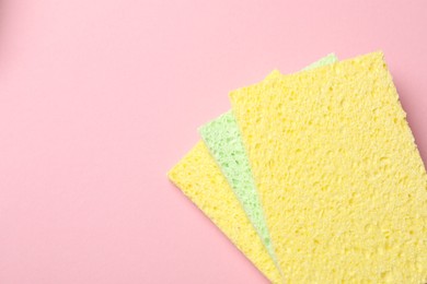 Photo of Soft sponges on pink background, top view. Space for text