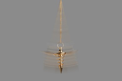 Image of Hypnosis session. Golden pendulum swinging on grey background, motion blur effect