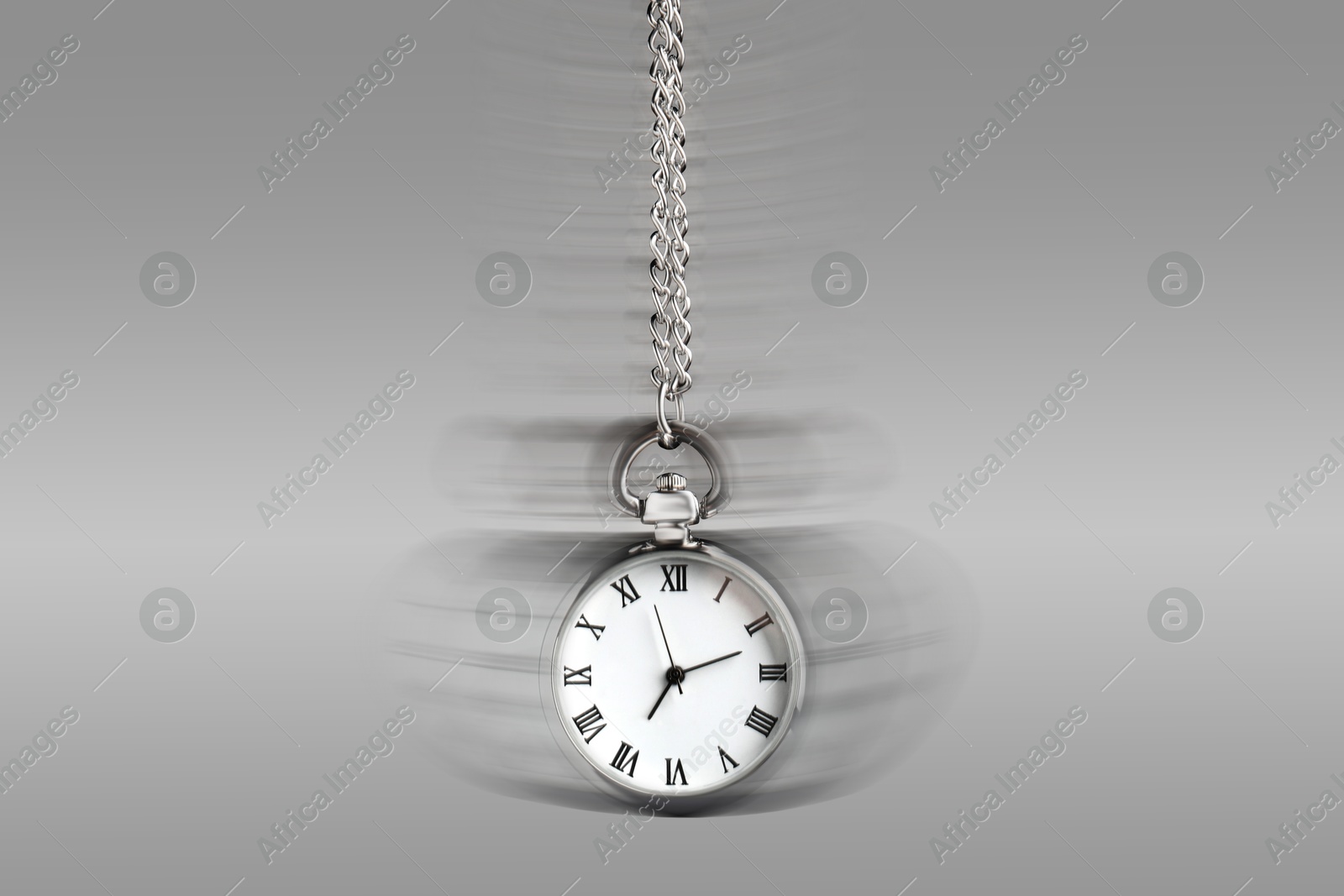 Image of Hypnosis session. Vintage pocket watch swinging on grey background, motion blur effect