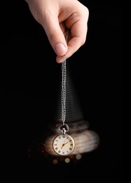 Image of Hypnosis session. Woman swinging vintage pocket watch on black background, motion blur effect