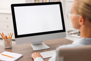 Woman working with computer monitor at table in office. Mockup for design