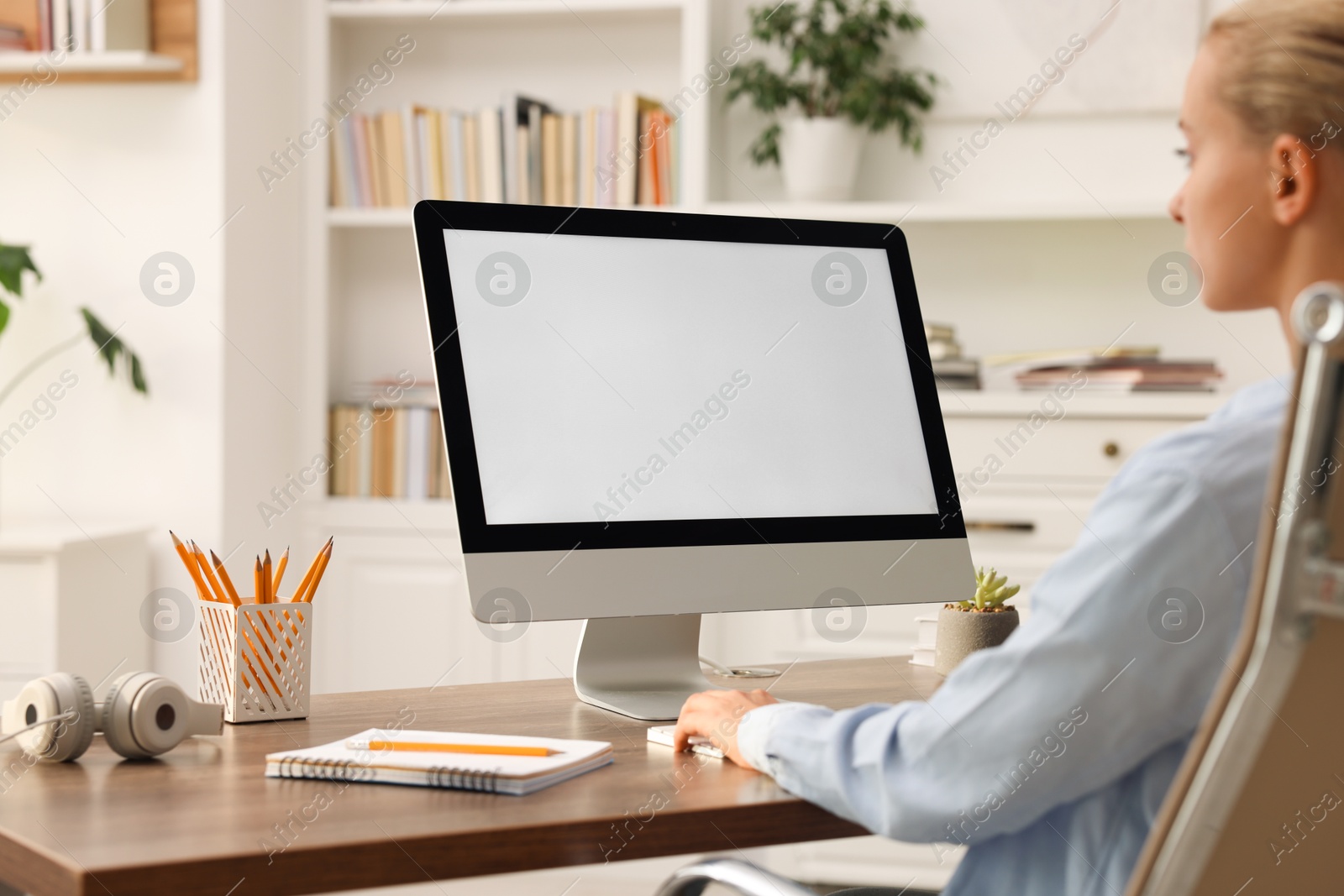 Photo of Woman working with computer monitor at table in office. Mockup for design