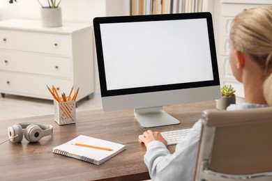 Woman working with computer monitor at table in office. Mockup for design