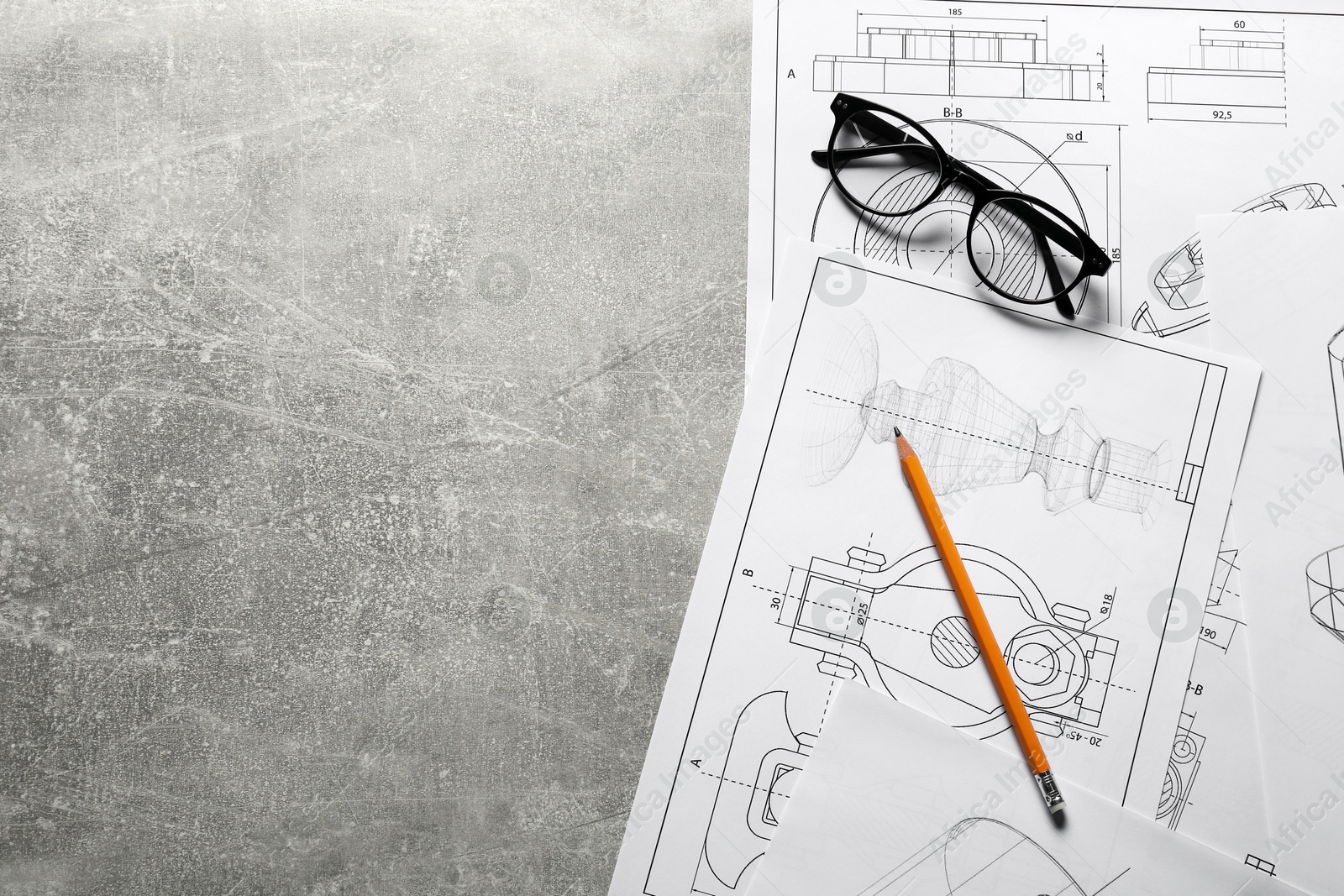 Photo of Different engineering drawings, pencil and glasses on gray textured table, top view. Space for text