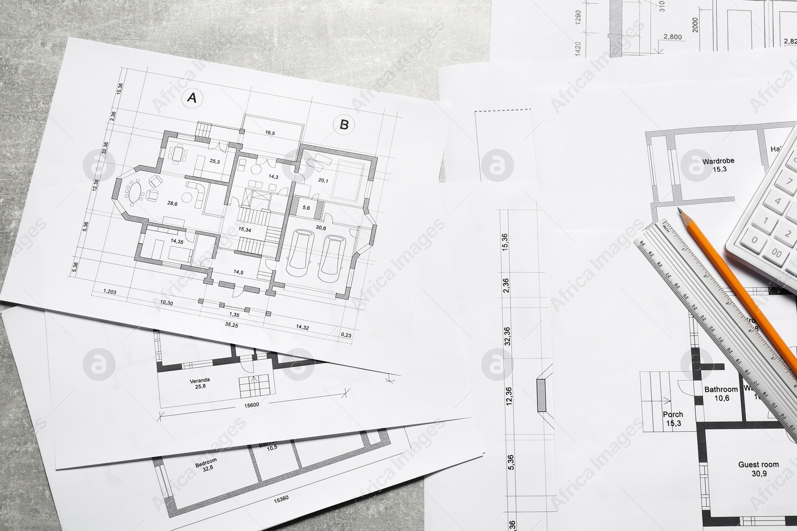 Photo of Different architectural drawings, calculator, ruler and pencil on gray textured table, top view