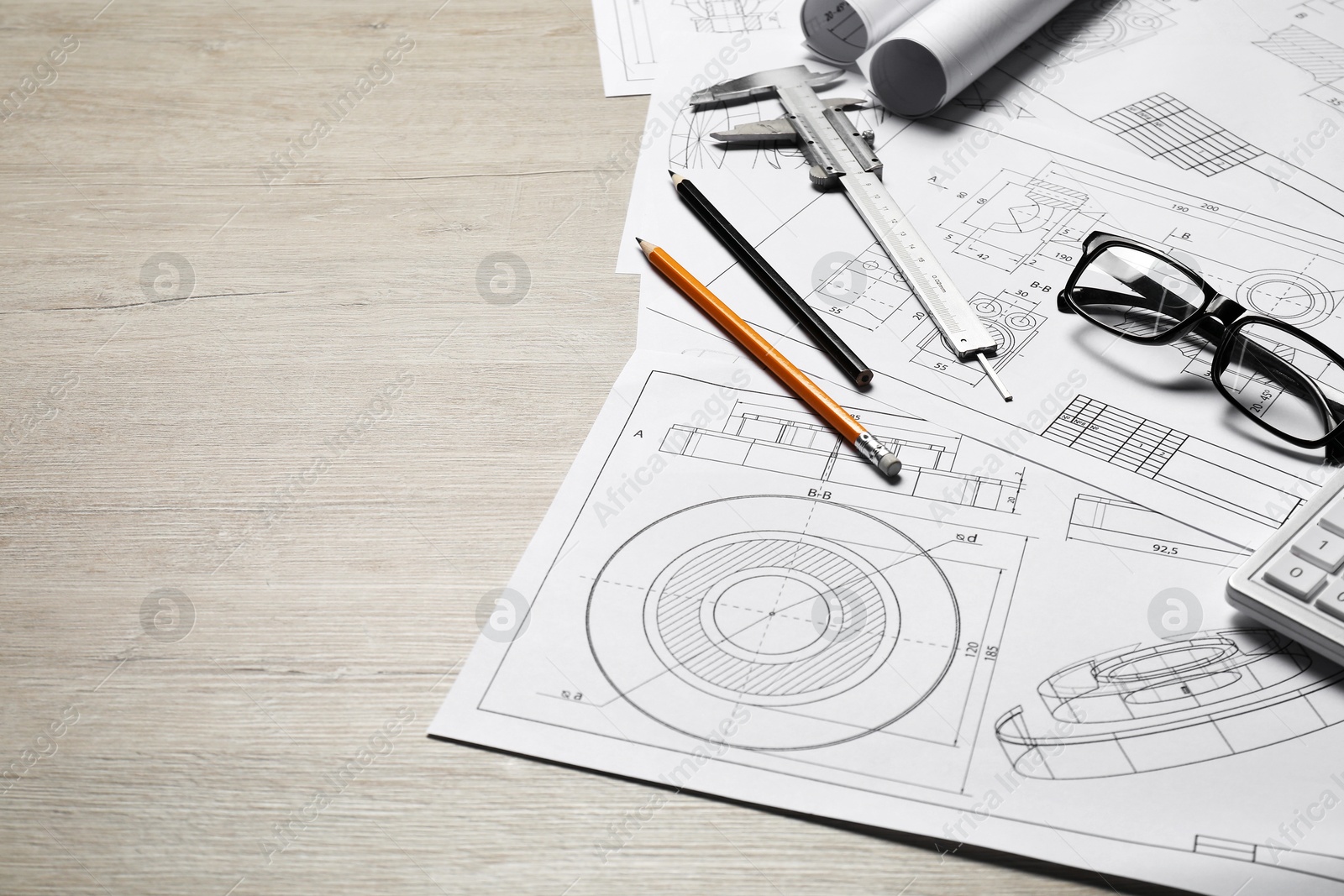 Photo of Different engineering drawings and tools on wooden table, space for text