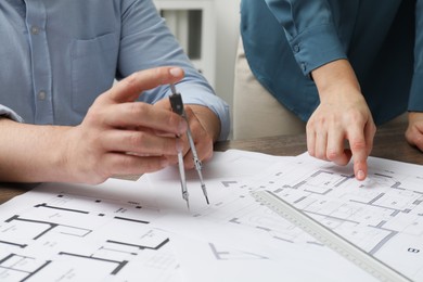 Photo of Architects working with project, closeup. Different technical drawings on table