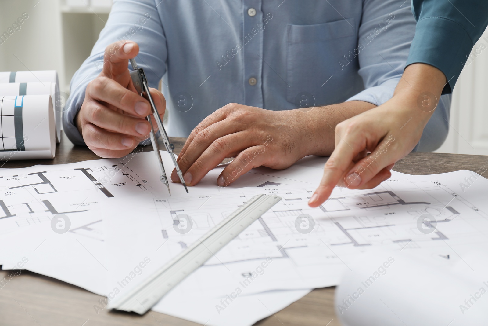 Photo of Architects working with project, closeup. Different technical drawings on wooden table