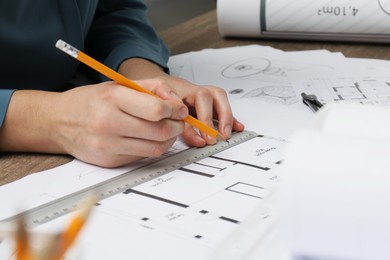 Photo of Architect working with project, closeup. Different technical drawings on table