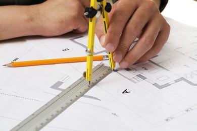 Photo of Architect working with project, closeup. Different technical drawings on table