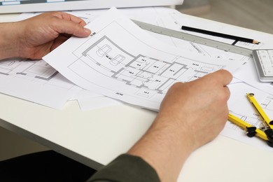 Photo of Architect working with project, closeup. Different technical drawings on white table