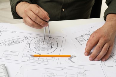 Photo of Engineer working with project, closeup. Different technical drawings on white table