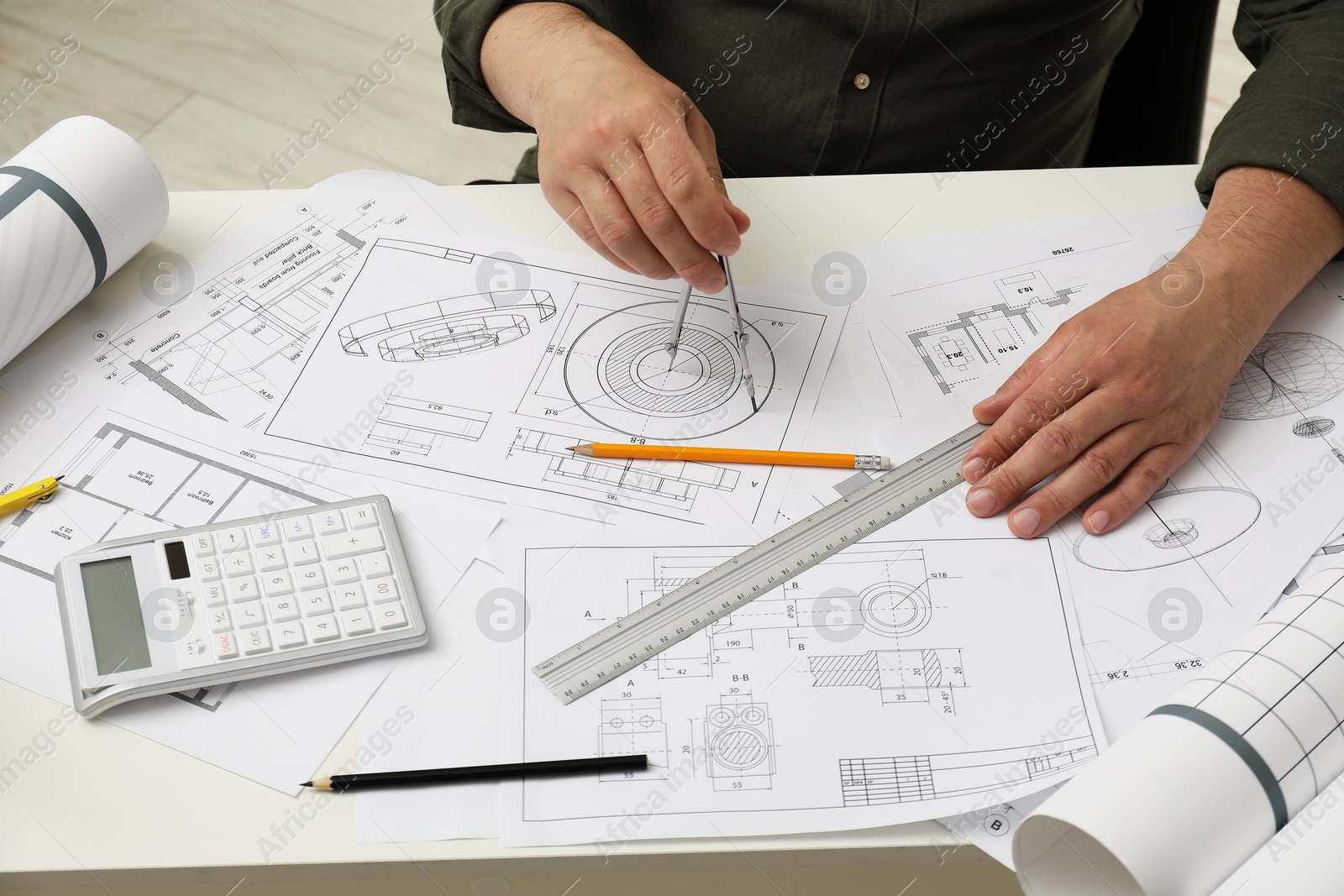 Photo of Engineer working with project, closeup. Different technical drawings on table