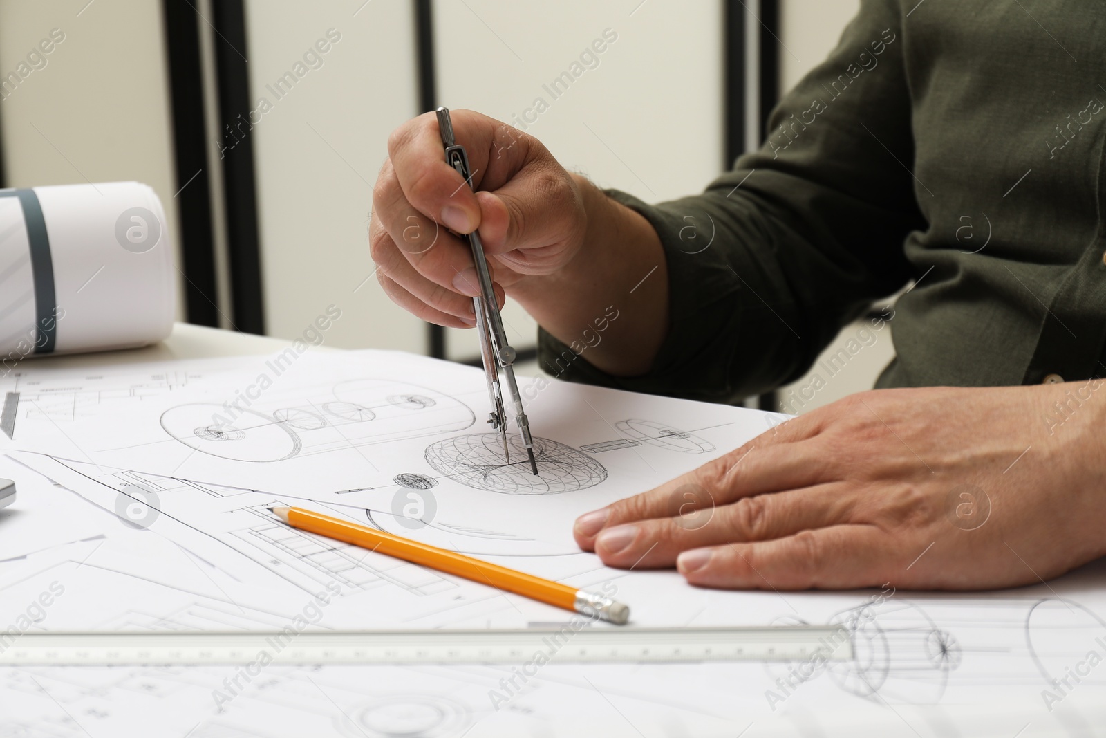 Photo of Engineer working with project, closeup. Different technical drawings on table