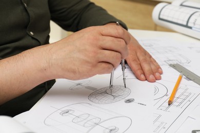 Photo of Engineer working with project, closeup. Different technical drawings on table