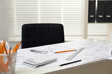 Photo of Different technical drawings and tools on table in office