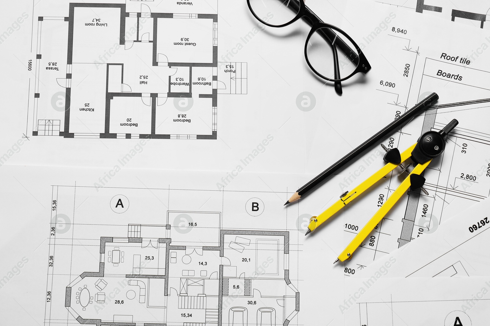 Photo of Different architectural drawings, pencil, glasses and divider on table, flat lay