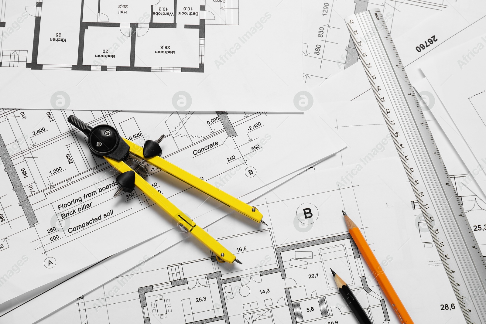 Photo of Different architectural drawings, ruler, pencils and divider on table, flat lay