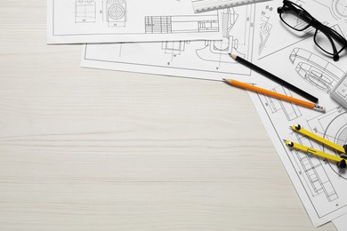 Photo of Different engineering drawings, pencils, glasses and divider on wooden table, flat lay. Space for text