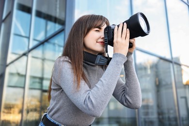 Photo of Professional photographer taking picture with camera outdoors