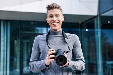 Photo of Professional photographer with camera near building outdoors