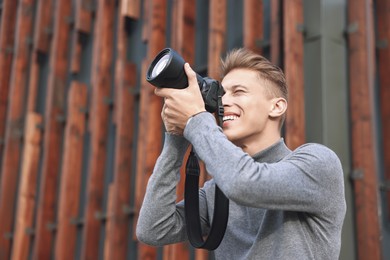 Photo of Professional photographer taking picture with camera outdoors